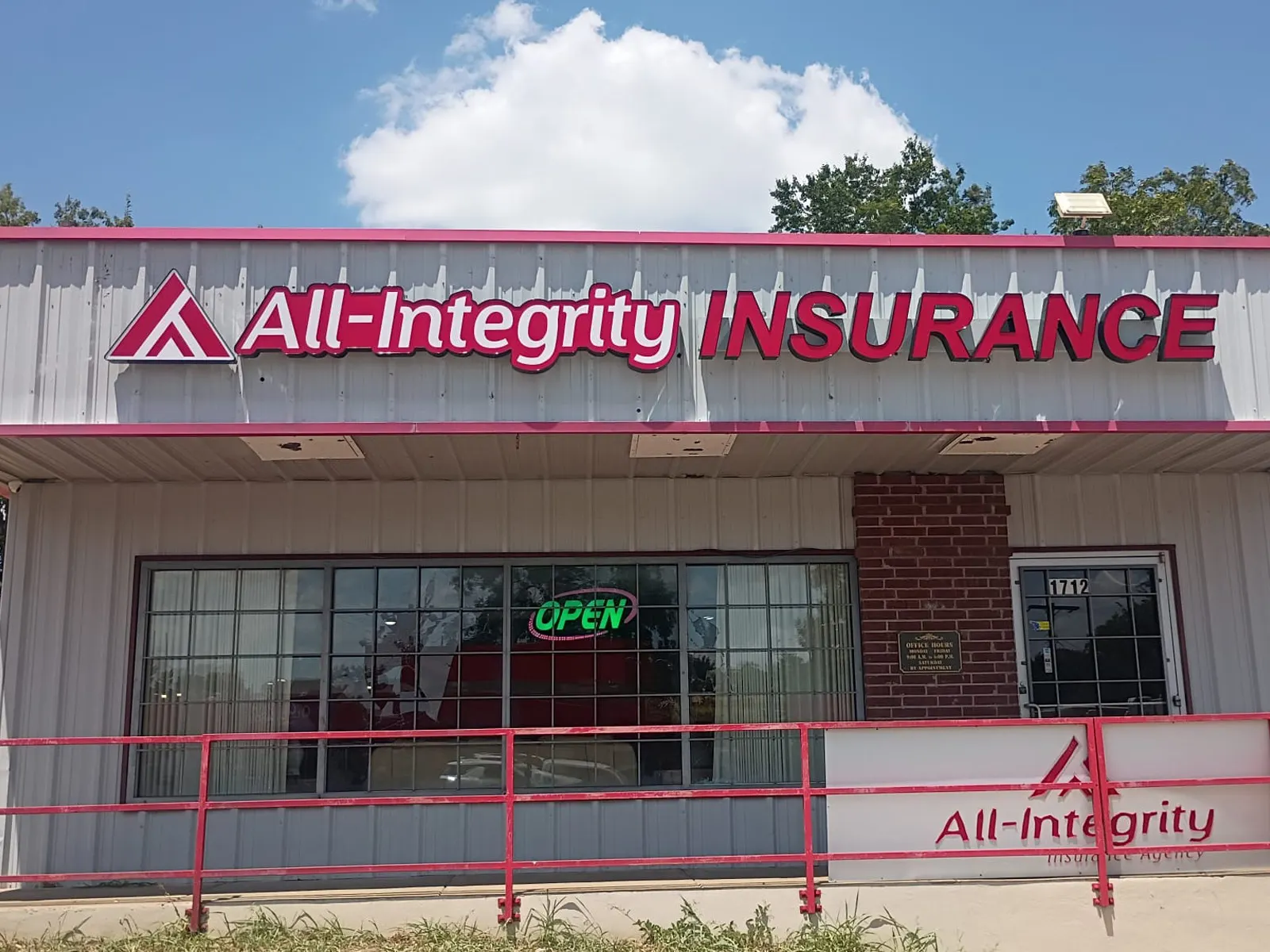All-Integrity Insurance red channel letters on a white metal fascia, with a matching logo panel on the porch rail