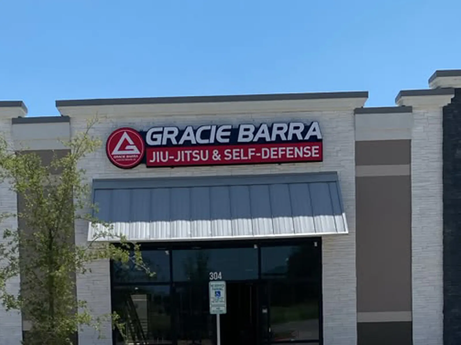 Gracie Barra Jiu-Jitsu and Self-Defense sign above a storefront with a metal awning