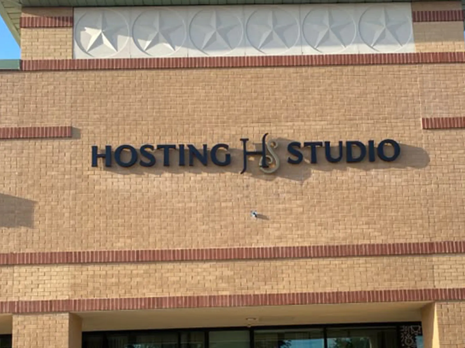 Hosting Studio dark dimensional letters and monogram on a brick wall