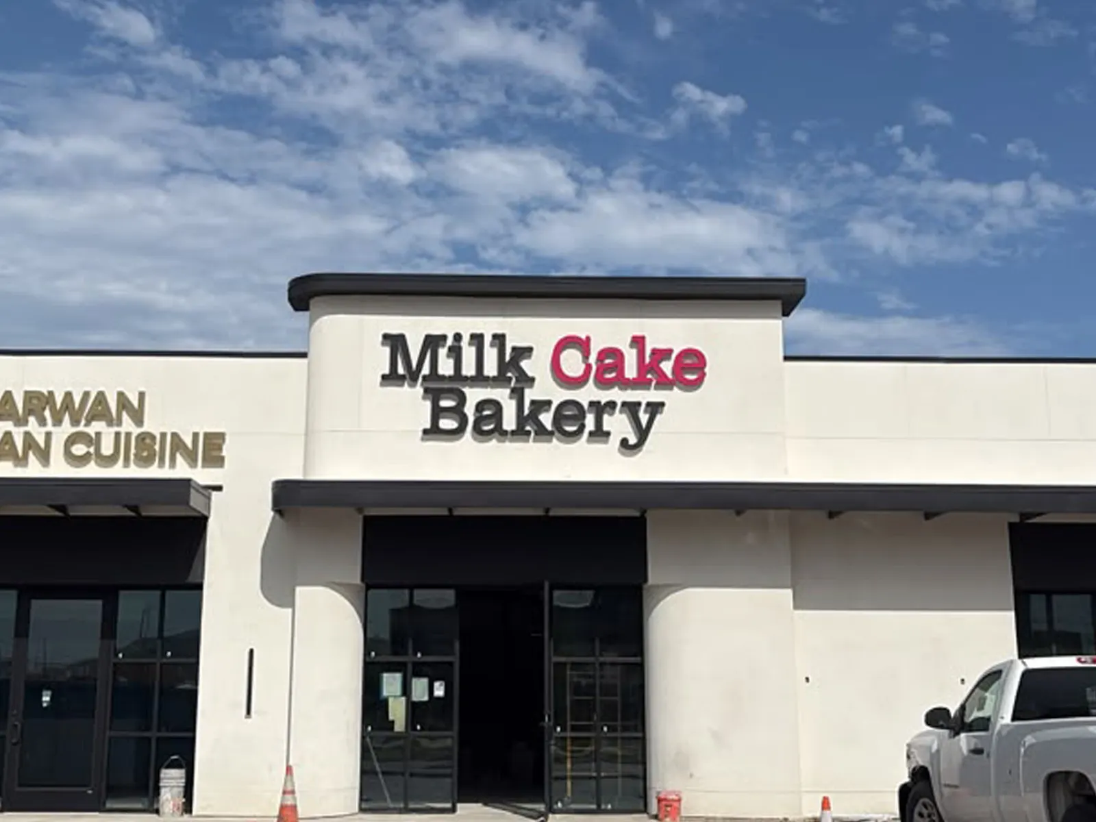Milk Cake Bakery channel letters above a stucco storefront