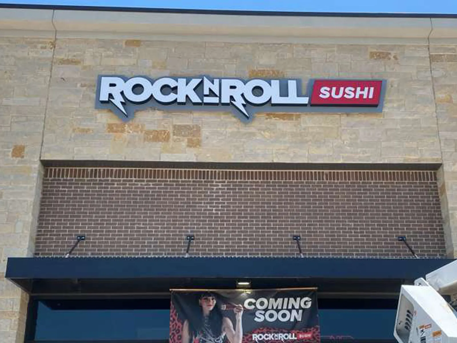 Rock N Roll Sushi channel letters on a stone facade with a coming soon banner below