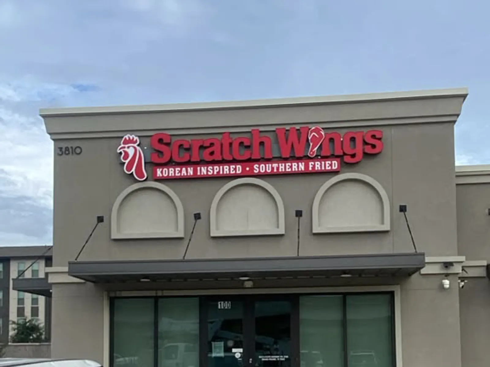 Scratch Wings red channel letters and rooster logo above a restaurant entrance