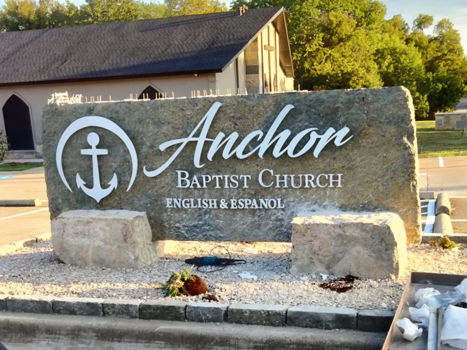 Anchor Baptist Church lettering and anchor logo on a natural stone monument