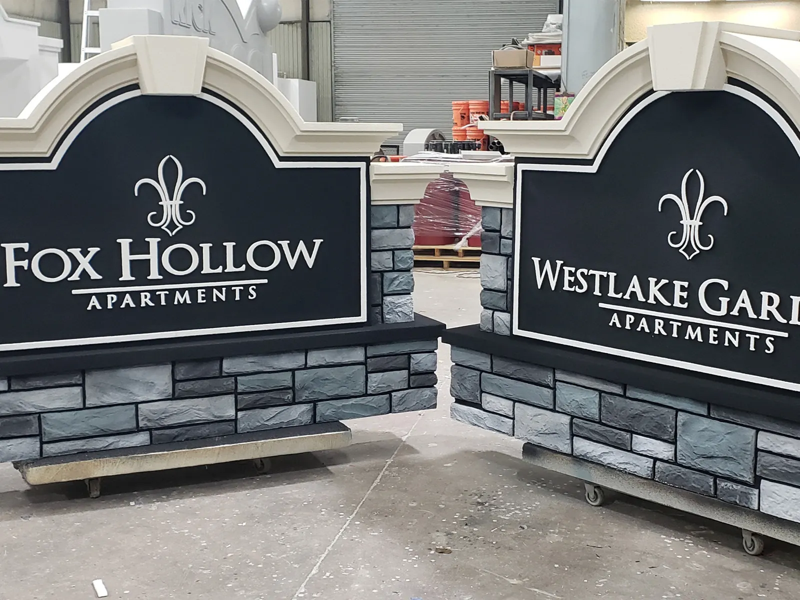 Fox Hollow and Westlake Gardens apartment monument signs with stone-look bases in the fabrication shop