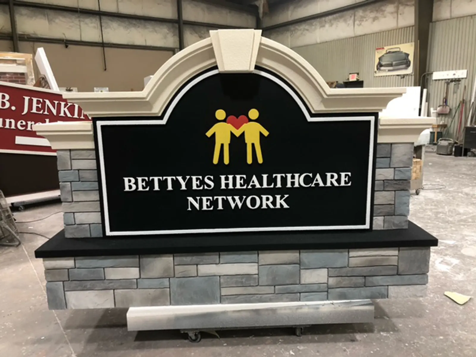 Bettyes Healthcare Network monument sign with an arched cap and stone-look base in the fabrication shop