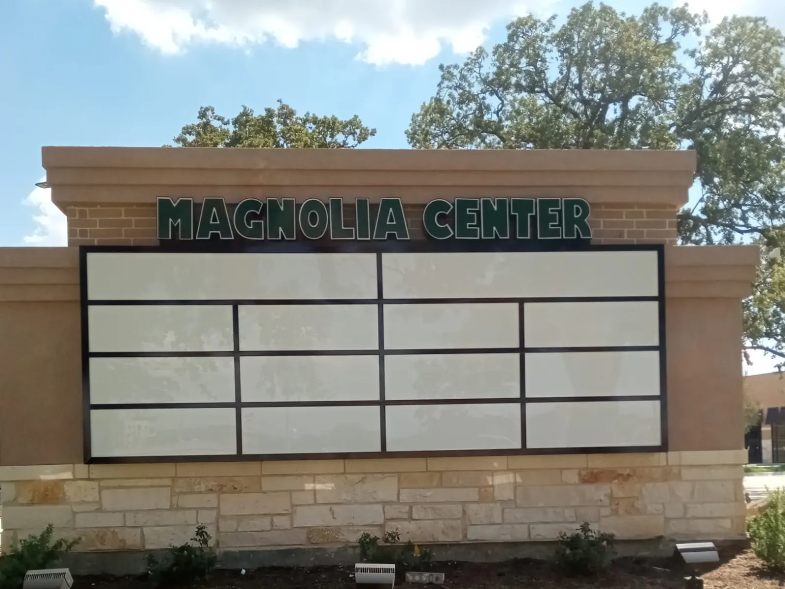 Magnolia Center multi-tenant monument sign with a stone base and tenant panel grid