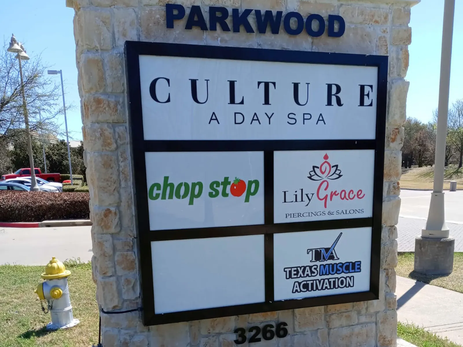 Parkwood multi-tenant sign with individual tenant panels set in a stone column